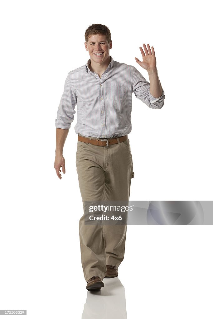 Portrait of a happy man walking and waving his hand