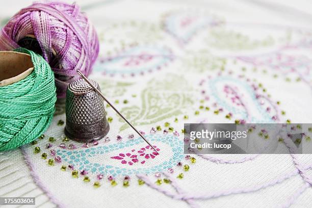 embroidery thread, needle and thimble on a embroidery. - embroidery stockfoto's en -beelden
