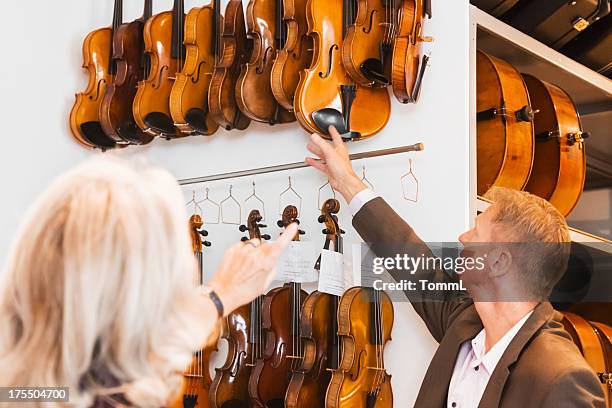 female customer buying violin - music shop stock pictures, royalty-free photos & images