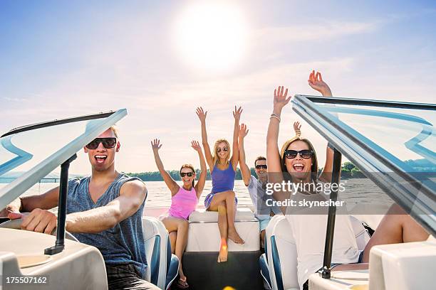 cheerful group of young people enjoying in speedboat ride. - boat party stock pictures, royalty-free photos & images