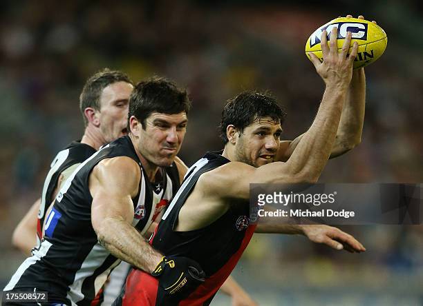 Patrick Ryder of the Bombers gets tackled bys by Quinten Lynch of the Magpies during the round 19 AFL match between the Collingwood Magpies and the...
