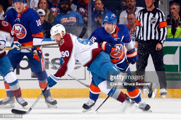 Cal Clutterbuck of the New York Islanders trips up Tomas Tatar of the Colorado Avalanche during the second period at UBS Arena on October 24, 2023 in...