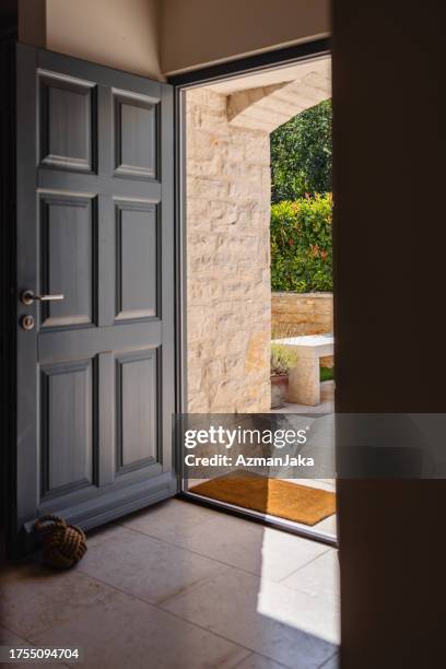 opened entrance doors of a mediterranean stone villa - doorway stock pictures, royalty-free photos & images