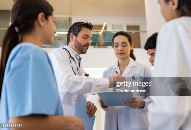 group of doctors discussing a medical chart at the hospital - civil imagens e fotografias de stock