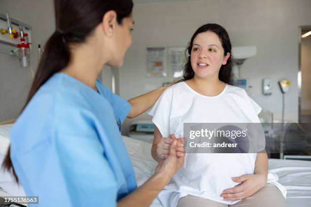 la madre estará de la mano de una partera mientras se prepara para el parto en el hospital - comadrona fotografías e imágenes de stock