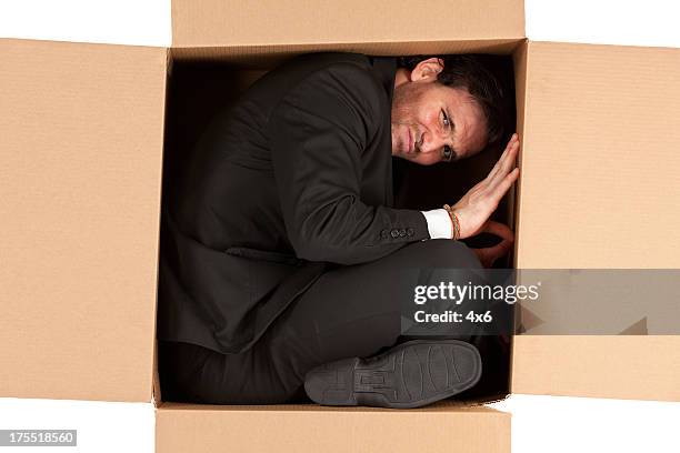homme d'affaires dans une boîte en carton - contortionist photos et images de collection
