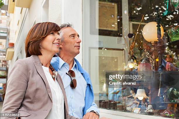 adult couple shopping in an antique shop - man in antique shop stock pictures, royalty-free photos & images