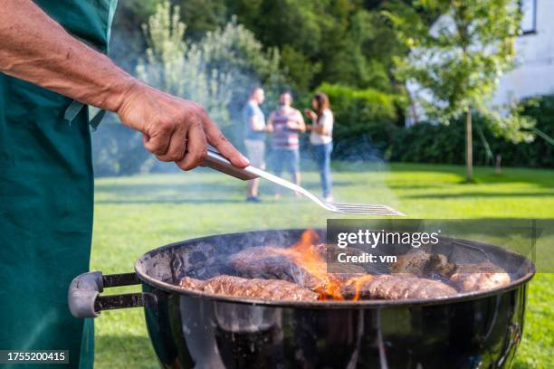 man roasting meat on an outdoor grill - spatula stock pictures, royalty-free photos & images