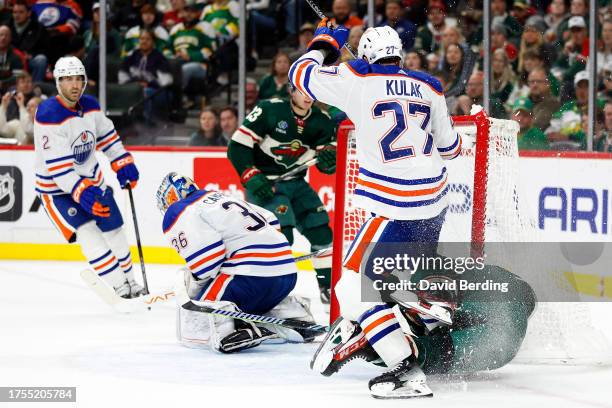 Brett Kulak of the Edmonton Oilers checks Marcus Foligno of the Minnesota Wild in the second period at Xcel Energy Center on October 24, 2023 in St...