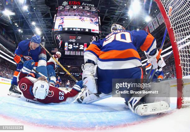 Noah Dobson of the New York Islanders dumps Artturi Lehkonen of the Colorado Avalanche during the second period at UBS Arena on October 24, 2023 in...