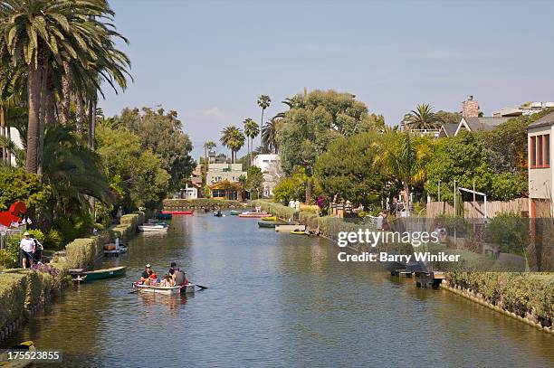 people in rowboat on narrow waterway - venice california canals stock pictures, royalty-free photos & images