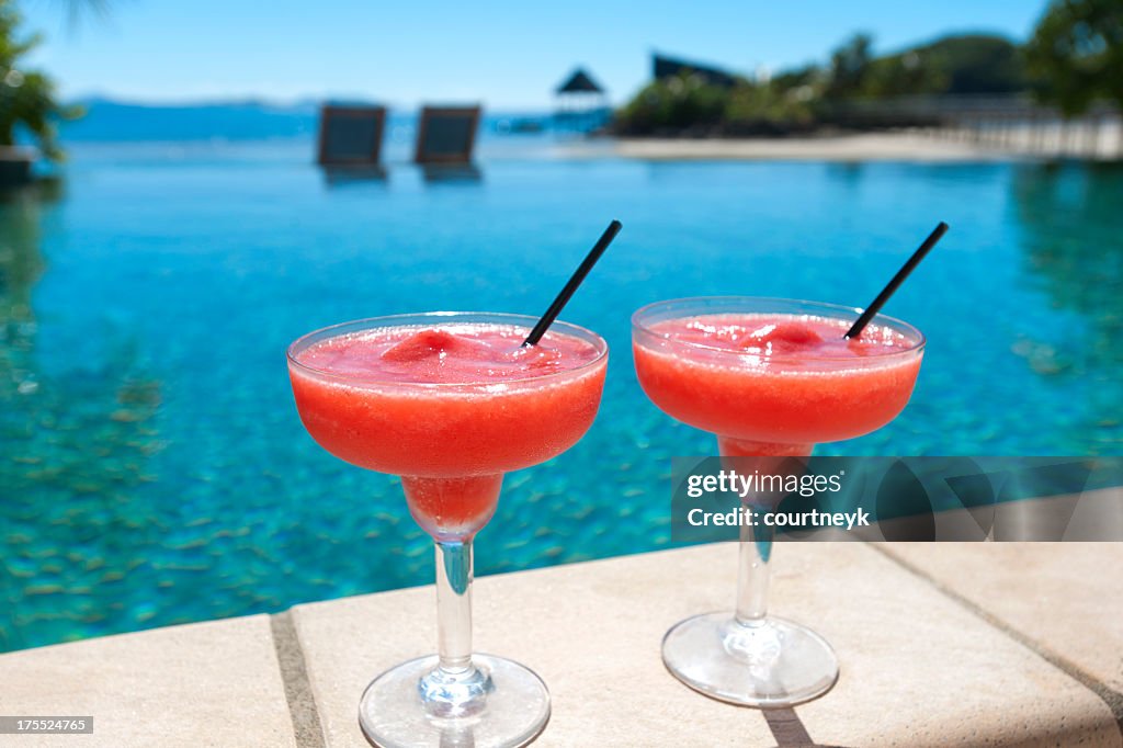 2 cocktails beside a resort swimming pool