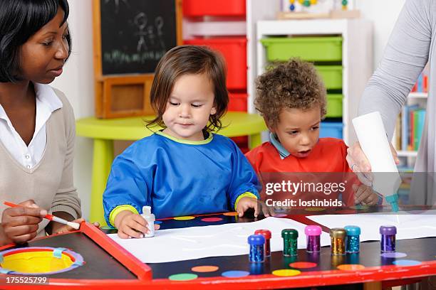 toddler/ little boy excited by carer squeezing glue - glue stock pictures, royalty-free photos & images