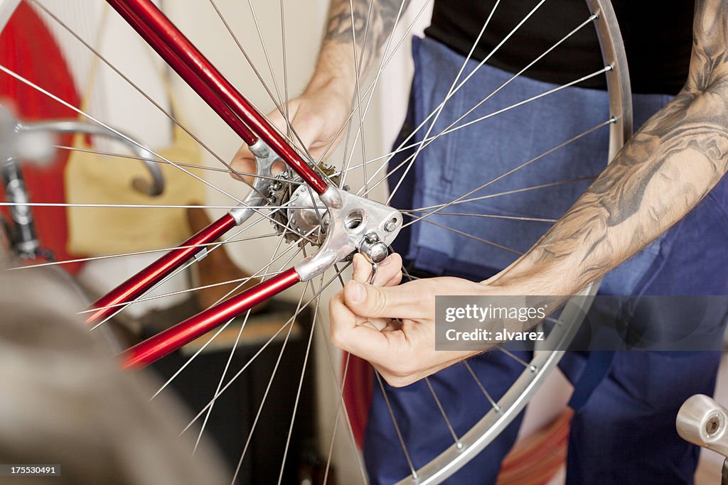 Mechanic fixing bike at bicycle shop