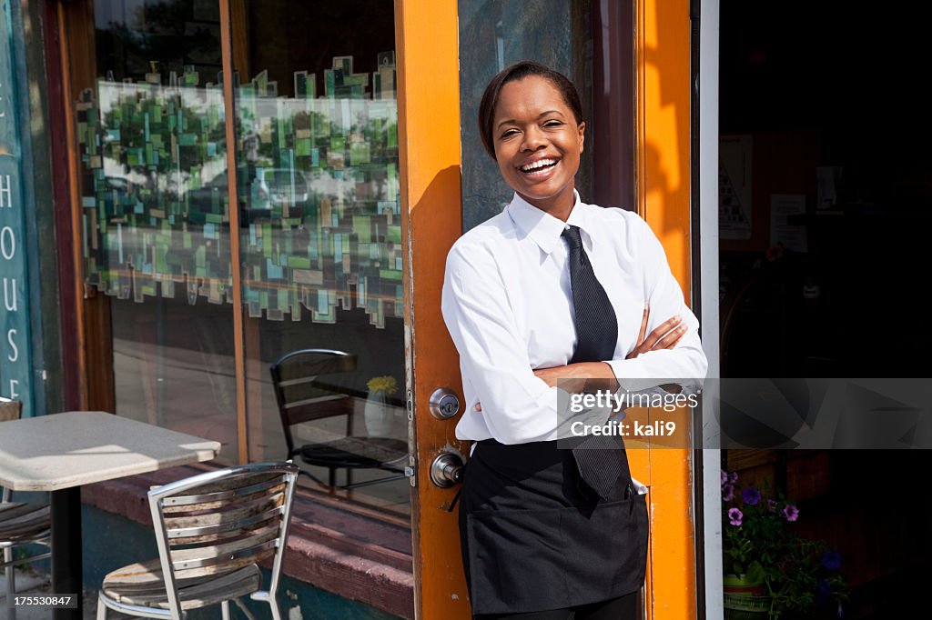 African American camarera de pie fuera del restaurante