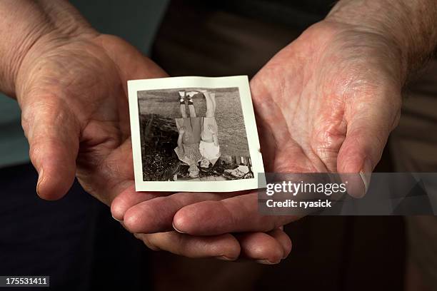 closeup of elderly couple hands holding old honeymoon photo - time flies stock pictures, royalty-free photos & images