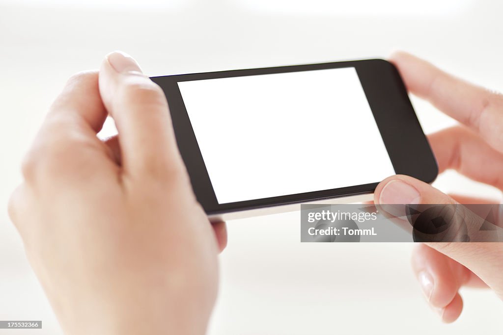 Hands holding a smart phone with a blank, white screen.