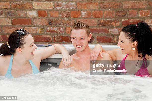 young man with two girls in hot tub - girls in hot tub stockfoto's en -beelden
