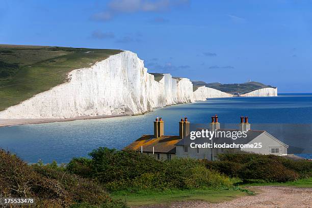 a house sits nestled along the coastline - seven sisters cliffs 個照片及圖片檔