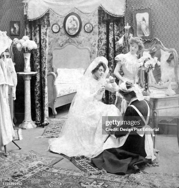 Life model stereoview from 1900 of a bride and groom having their photograph taken. A humorous slide entitled 'Just one Darling, while his head is...