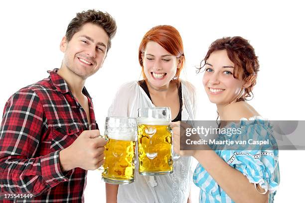 young beer fest visitors partying with beer steins - beer stein stockfoto's en -beelden