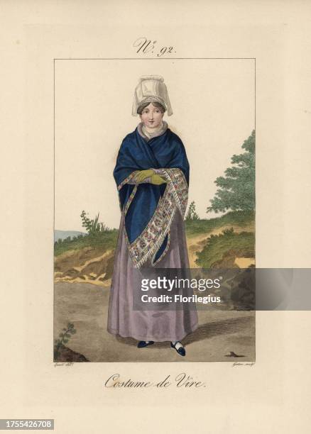 Costume of Vire. The bonnet is a bavolet with short tails, the hair is separated at the front and rolled in curls over the temples, with a short...