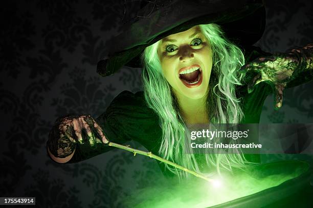 halloween witch conjuring a spell - tovenaar stockfoto's en -beelden