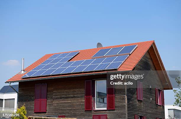 hölzerne eine familie haus mit solarzellen auf dem dach - einfamilienhaus mit solarzellen stock-fotos und bilder