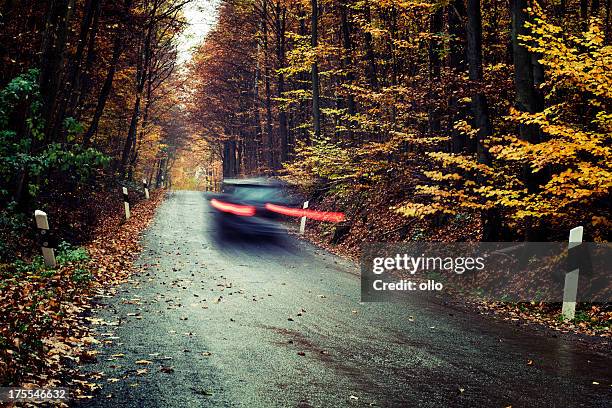 car-pässe von auf einem herbstlichen wald road - car brakes stock-fotos und bilder