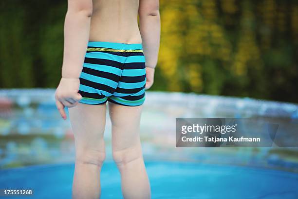 back view of a little boy in swimming trunks - planschbecken stock-fotos und bilder