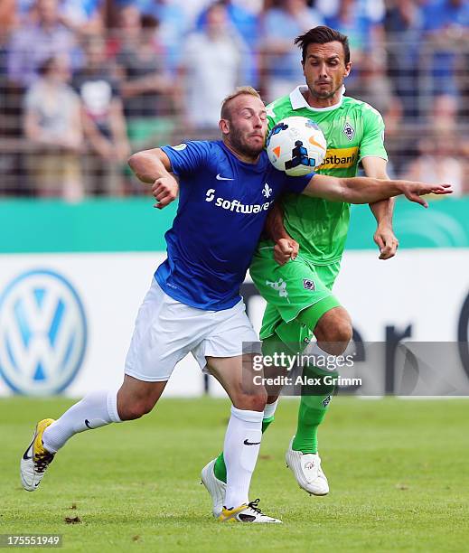 Marco Sailer of Darmstadt is challenged by Martin Stranzl of Moenchengladbach during the DFB Cup first round match between Darmstadt 98 and Borussia...