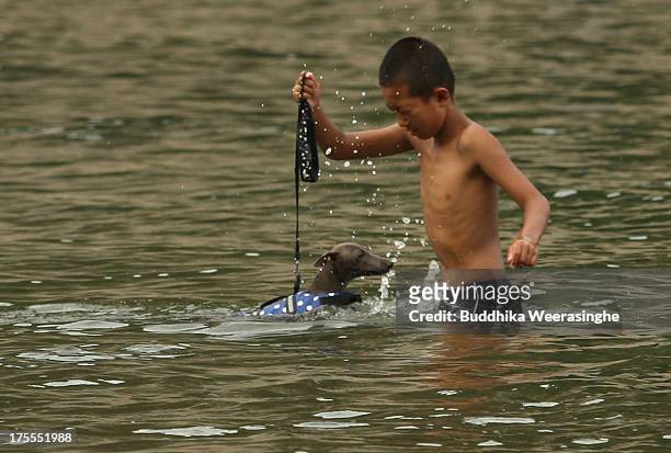 Boy bathes his pet dog in the water at Takeno Beach on August 4, 2013 in Toyooka, Japan. This beach is open for dogs and their owners every summer...