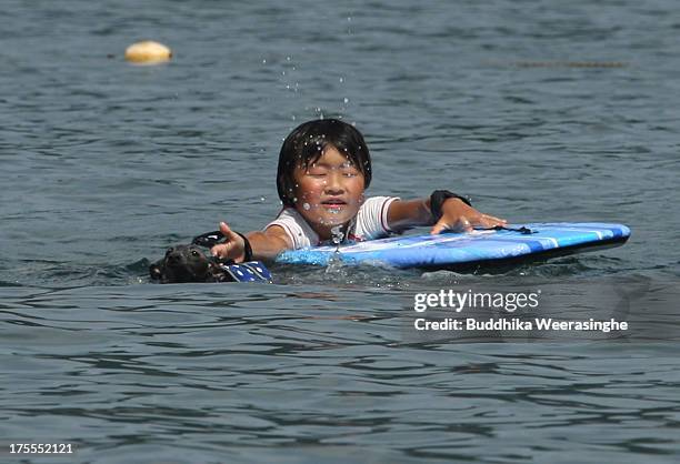 Boy bathes his pet dog in the water at Takeno Beach on August 4, 2013 in Toyooka, Japan. This beach is open for dogs and their owners every summer...