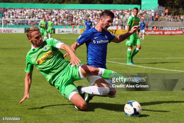 Marcel Heller of Darmstadt is challenged by Filip Daems of Moenchengladbach during the DFB Cup first round match between Darmstadt 98 and Borussia...