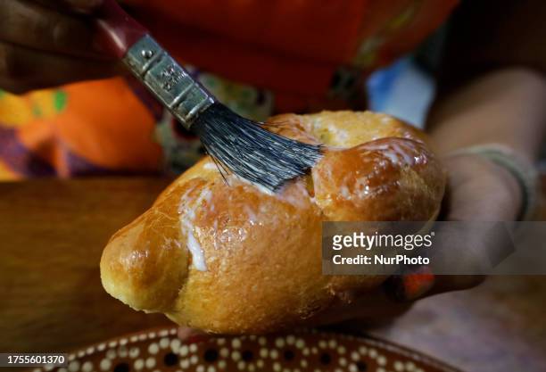 View of varnishing Pan de Muerto to decorate it with Totomoxtle Ash on the eve of Day of the Dead in Mexico. Totomoxtle, commonly known as the husk...