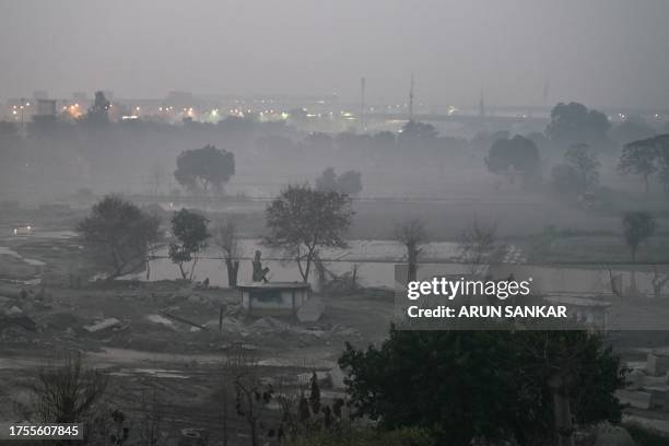 Person walks in smoggy conditions at Yamuna flood plains in New Delhi on October 31, 2023.