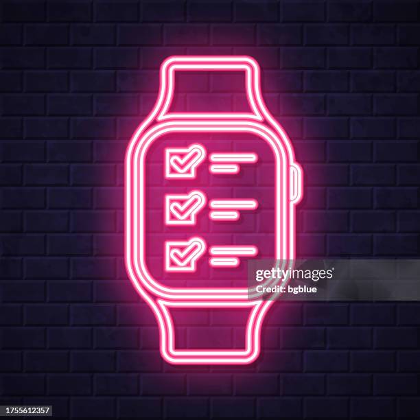 smartwatch with checklist. glowing neon icon on brick wall background - checking smart watch stock illustrations