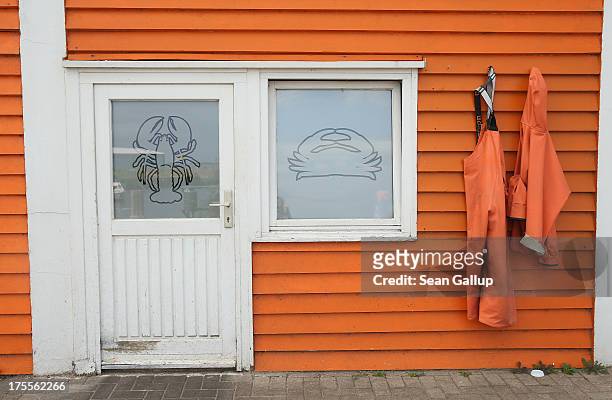 Crab fisher's waders and jacket hang on the outside of a house in Helgoland town on August 3, 2013 on Heligoland Island, Germany. Heligoland Island,...