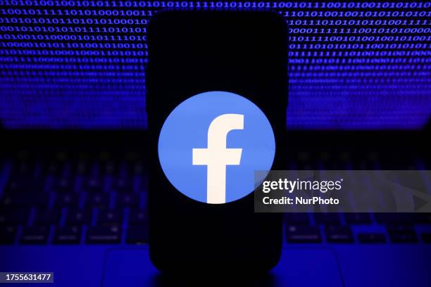 Binardy code displayed on a laptop screen and Facebook logo displayed on a phone screen are seen in this illustration photo taken in Krakow, Poland...