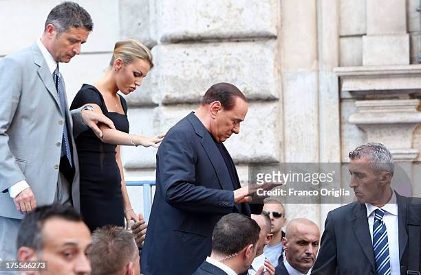 Former Prime Minister Silvio Berlusconi flanked by his girlfriend Francesca Pascale leaves the stage after speaking to supporters during a...
