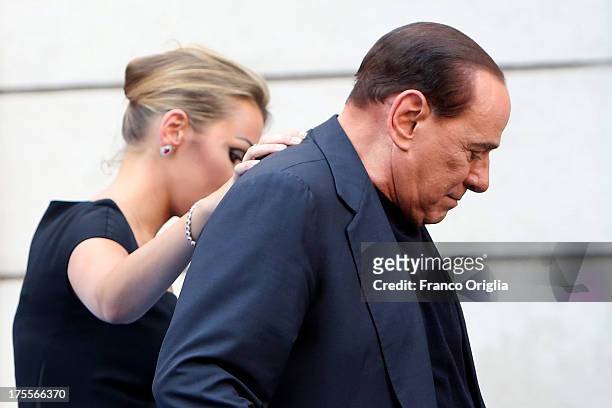 Former Prime Minister Silvio Berlusconi flanked by his girlfriend Francesca Pascale leaves the stage after speaking to supporters during a...