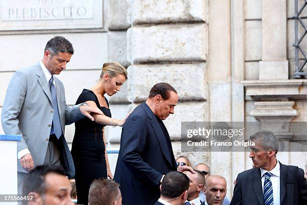 Former Prime Minister Silvio Berlusconi flanked by his girlfriend Francesca Pascale leaves the stage after speaking to supporters during a...