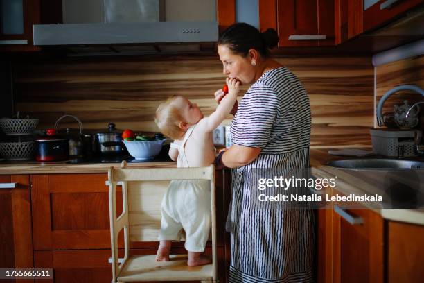 montessori kitchen helper: middle-aged mom and baby's sensory adventure - montessori foto e immagini stock