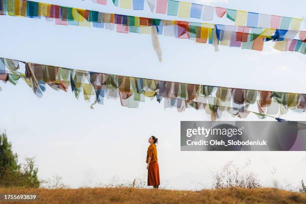 woman on the background of tibetan prayer flags and sky - peace un stock pictures, royalty-free photos & images