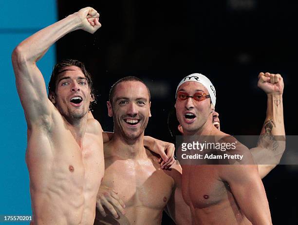 Camille Lacourt, Fabien Gilot and Jeremy Stravius of France celebrate after the USA are disqualified and they are instated as winners of the Swimming...