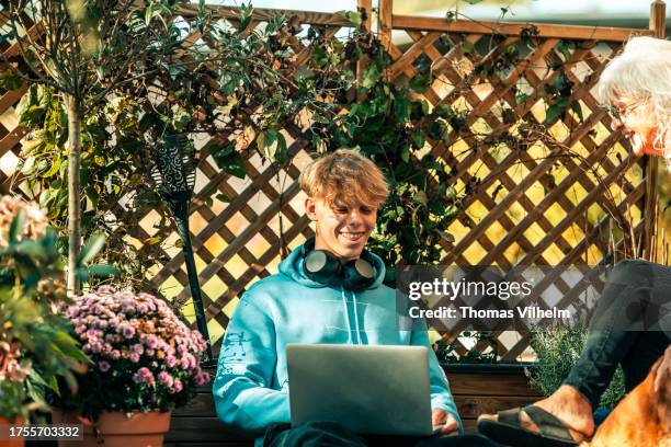 teenage boy and grandmother together in the garden. - multi generational family with pet stock pictures, royalty-free photos & images