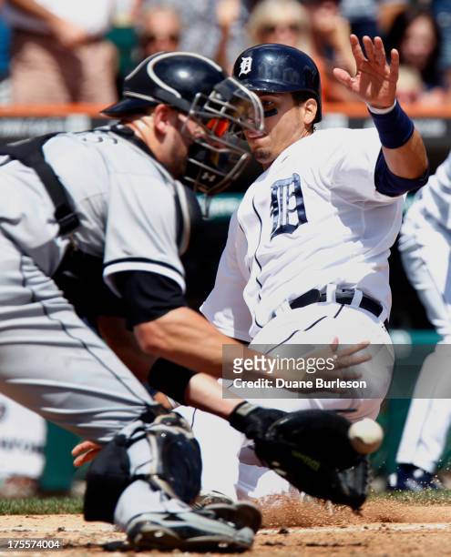 Victor Martinez of the Detroit Tigers beats the throw to catcher Tyler Flowers of the Chicago White Sox to score on a double by Alex Avila in the...