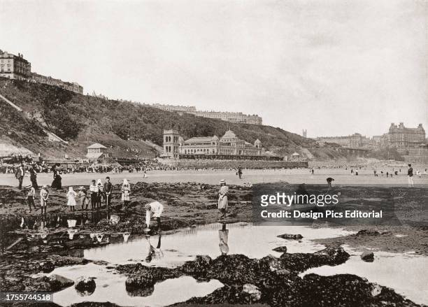 View from the rocks of South Bay and the Spa, Scarborough, North Yorkshire, England, seen here in the 19th century. From Around The Coast, An Album...