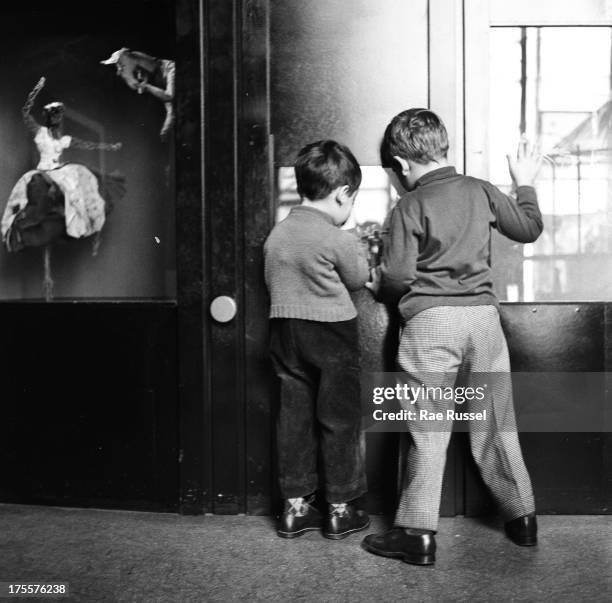 View from behind of two young boys as they look over an example of artwork during a children's art class at the Museum of Modern Art, New York, New...