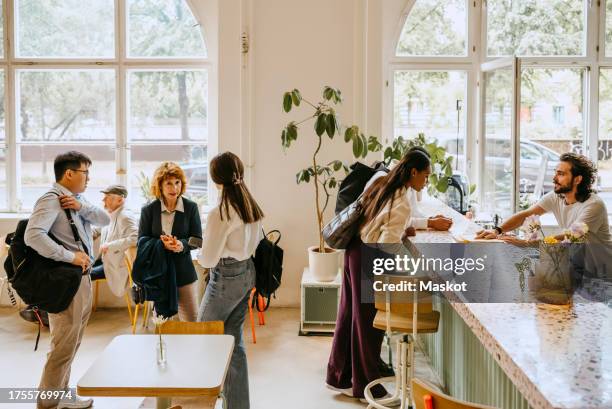 friends waiting in line while customers ordering to restaurant owner - restaurant queue stock pictures, royalty-free photos & images